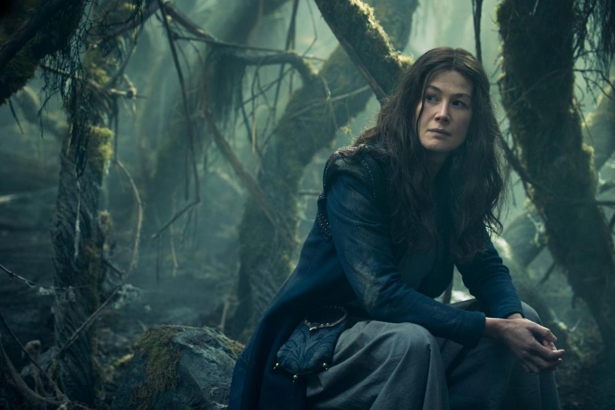 rosamund pike sitting in forest in wheel of time