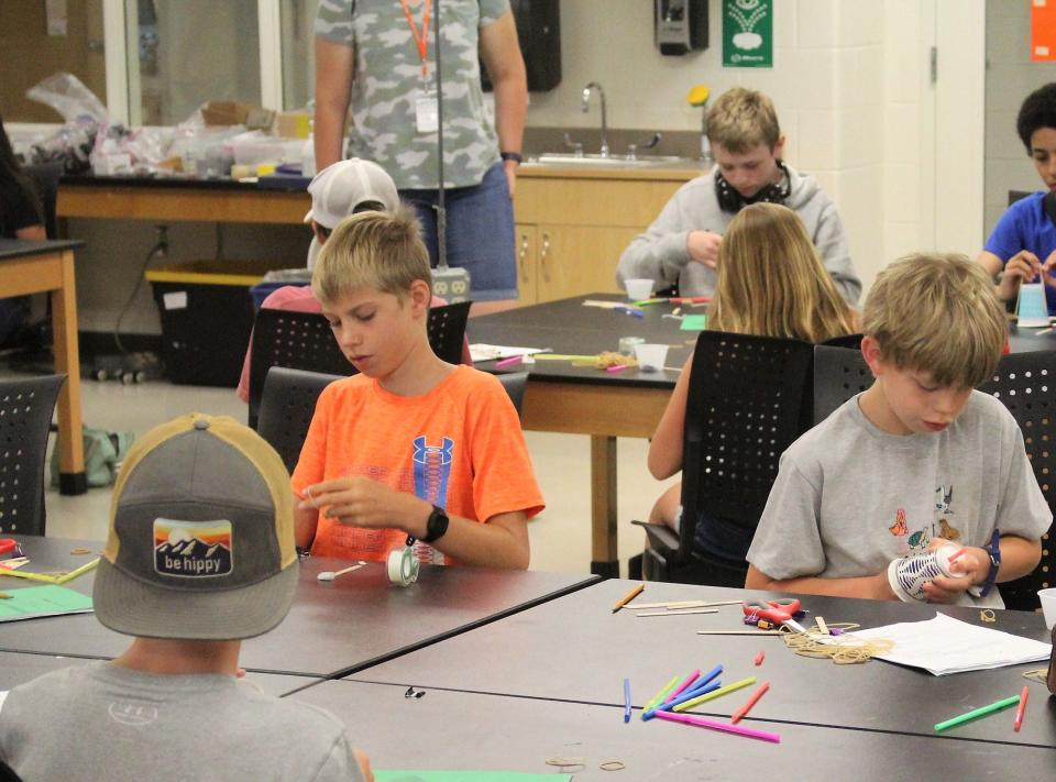 Students in an ExploreHope Summer Science Camp participate in an activity to create a device that can take a core sample from modeling clay.