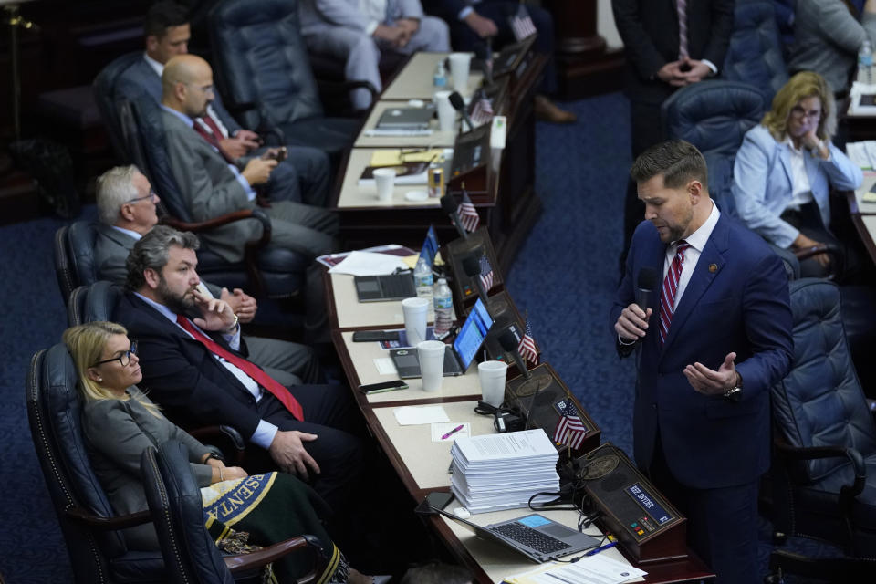 Florida Rep. John Snyder, standing right, speaks about an immigration bill before its passage during a legislative session at the Florida State Capitol, Wednesday, March 9, 2022, in Tallahassee, Fla. All Florida government agencies would be barred from doing business with transportation companies that bring immigrants to the state who are in the country illegally under a bill sent to Gov. Ron DeSantis on Wednesday. (AP Photo/Wilfredo Lee)