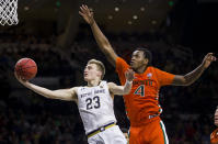 Notre Dame's Dane Goodwin (23) goes in for a layup over Miami's Keith Stone (4) during the second half of an NCAA college basketball game Sunday, Feb. 23, 2020, in South Bend, Ind. (AP Photo/Robert Franklin)