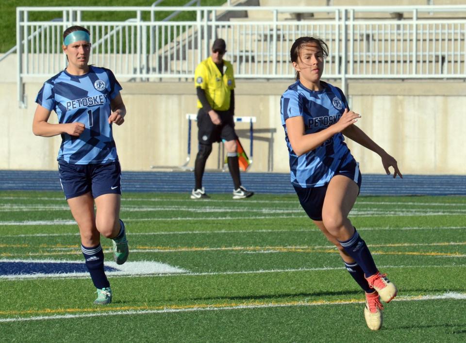 Petoskey seniors Haley Dixon (left) and Alaina Anderson follow the ball to the sideline against the Titans.