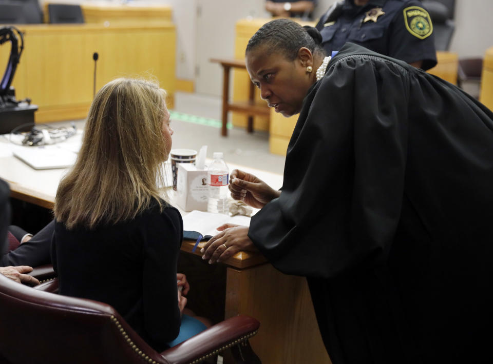 Former Dallas Police Officer Amber Guyger, left, listens to words of advice and encouragement from State District Judge Tammy Kemp after the judge had given her a Bible and before Guyger left for jail, Wednesday, Oct. 2, 2019, in Dallas. Guyger, who said she mistook neighbor Botham Jean's apartment for her own and fatally shot him in his living room, was sentenced to a decade in prison. (Tom Fox/The Dallas Morning News via AP, Pool)