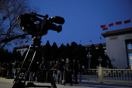 Members of the media line up outside the Great Hall of the People before dawn, ahead of the closing session of the National People's Congress (NPC) in Beijing, China March 15, 2019. REUTERS/Thomas Peter