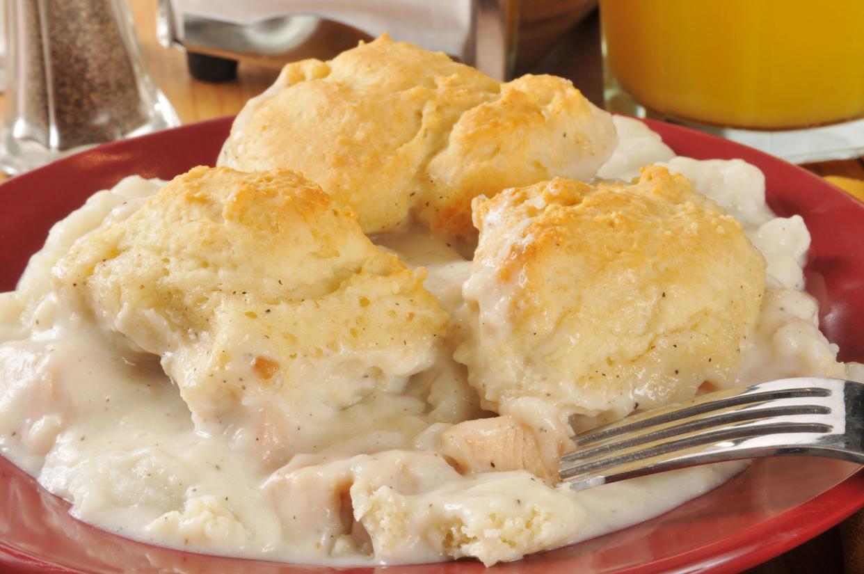chicken and gravy on a bed of mashed potatoes, topped with golden flaky biscuits