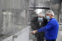 Rabbi Mendel Einhorn, left, looks on as foreman Dave Garthe runs boiling water through and over machinery in preparation for Hanan Products kosher-for-passover production run, Thursday, Jan. 7, 2021, in Hicksville, N.Y. (AP Photo/Seth Wenig)