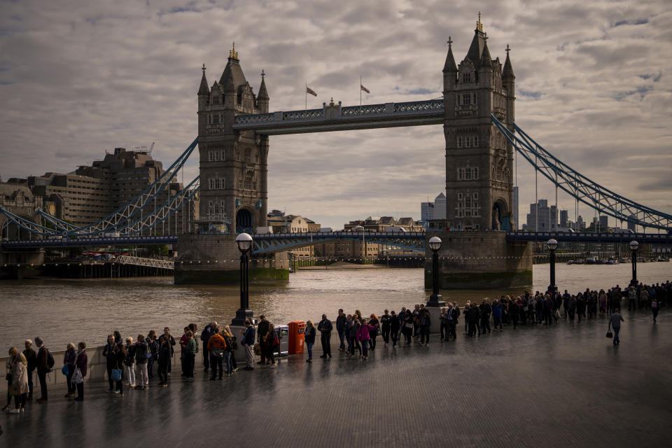 People queue near London Bridge to pay their respects to late Queen Elizabeth II during the Lying-in State, at Westminster Hall in London, Friday, Sept. 16, 2022. The Queen will lie in state in Westminster Hall for four full days before her funeral on Monday Sept. 19. (AP Photo/Emilio Morenatti)