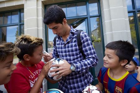 Uruguayan striker Luis Suarez (C) signs autographs after his hearing at the Court of Arbitration for Sport (CAS) in Lausanne August 8, 2014. REUTERS/Denis Balibouse