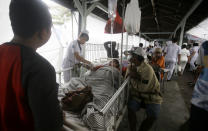 Patients are evacuated outside a hospital, following an earthquake in Bali, Indonesia, Monday, Aug. 6, 2018. A powerful earthquake struck the Indonesian tourist island of Lombok on Sunday, shaking neighboring Bali, one week after another quake on Lombok killed more than a dozen. (AP Photo/Firdia Lisnawati)