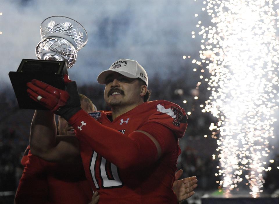 Texas Tech linebacker Jacob Rodriguez (10) raises his trophy as the outstanding defensive player in the Independence Bowl on Saturday night in Shreveport, Louisiana. Tech beat California 34-14, and Rodriguez was credited with six tackles, an interception, a caused fumble and a pass breakup.