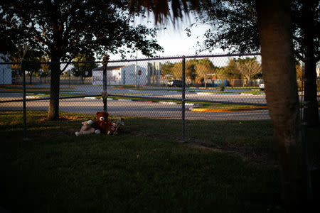 Stuffed toys and flowers left by people to commemorate the victims of the mass shooting are seen next to a fence at Marjory Stoneman Douglas High School in Parkland, Florida, U.S., February 19, 2018. REUTERS/Carlos Garcia Rawlins