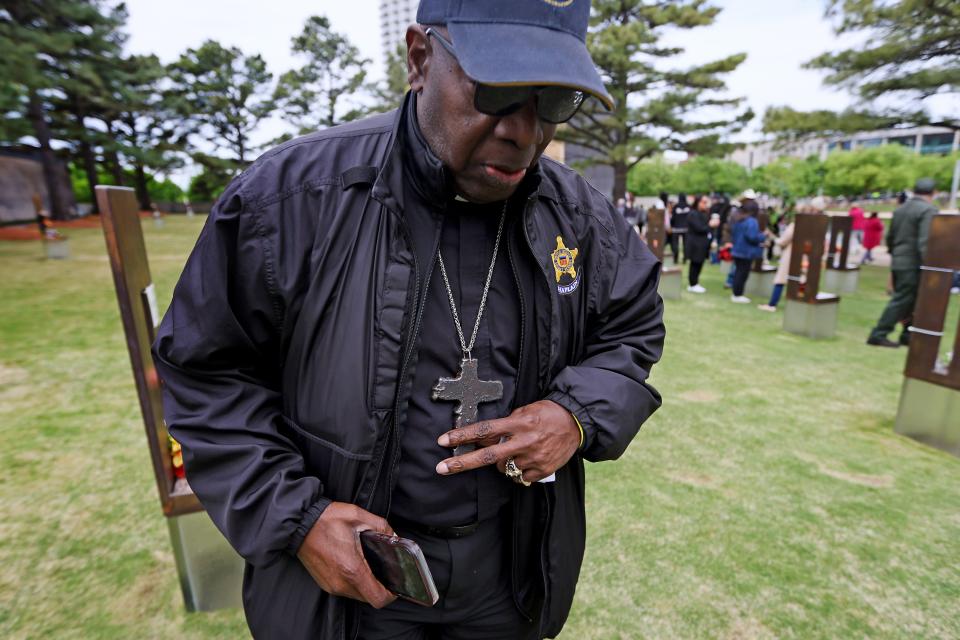 The Rev. Bill Minson, a chaplain during the 9/11 attacks, wears a cross made of steel from the south tower, as he visits the Field of Empty Chairs on Friday after the 29th annual Remembrance Ceremony at the Oklahoma City National Memorial & Museum.