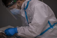 A health team member of the new Nurse Isabel Zendal Hospital checks on a patient inside a COVID-19 ICU in Madrid, Spain, Monday, Jan. 18, 2021. As the coronavirus curve of contagion turned increasingly vertical after Christmas and New Year's, the Zendal has been busy. On Monday, 392 virus patients were being treated, more than in any other hospital in the Madrid region. (AP Photo/Bernat Armangue)