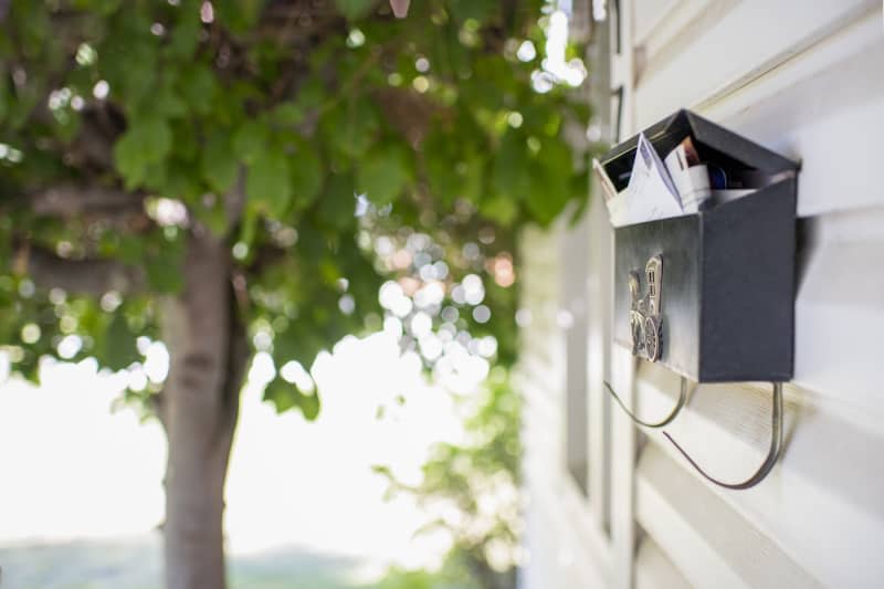 mailbox on side of house full of mail