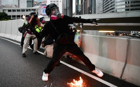 A protester throws a molotov cocktail towards police in the Admiralty area  - Credit: ANTHONY WALLACE/&nbsp;AFP