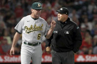 Oakland Athletics manager Bob Melvin, left, questions umpire Mark Carlson on a video replay decision during the seventh inning of the team's baseball game against the Los Angeles Angels in Anaheim, Calif., Saturday, Sept. 18, 2021. (AP Photo/Alex Gallardo)