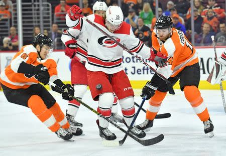 Apr 6, 2019; Philadelphia, PA, USA; Carolina Hurricanes left wing Brock McGinn (23) blocks shot as Philadelphia Flyers defenseman Travis Sanheim (6) and center Sean Couturier (14) reach for the puck during the second period at Wells Fargo Center. Mandatory Credit: Eric Hartline-USA TODAY Sports