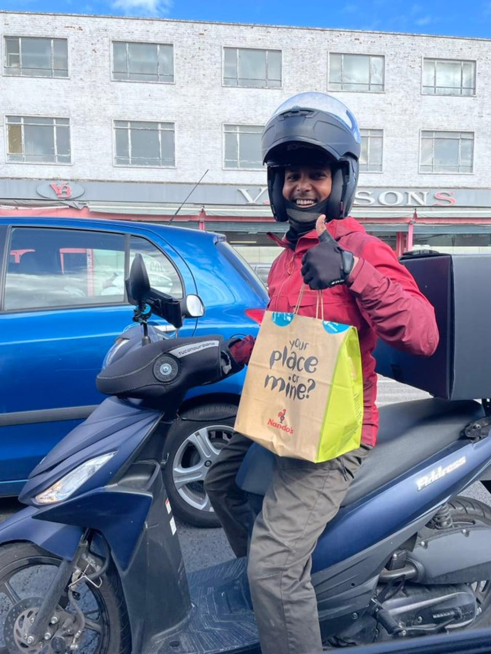 A delivery rider arriving at a petrol station with a takeaway order (Twitter/ Lily Potkin)