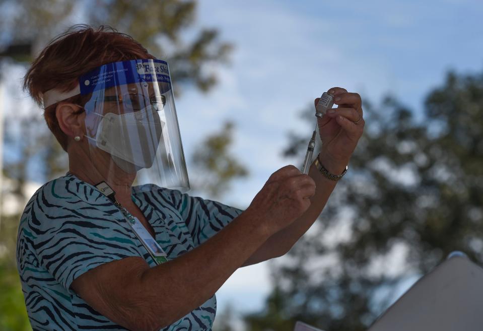 Lynnette Essig, a licensed practical nurse with the Visiting Nurse Association, prepares a dose of influenza vaccine Wednesday, Oct. 7, 2020, in Vero Beach, Fla.