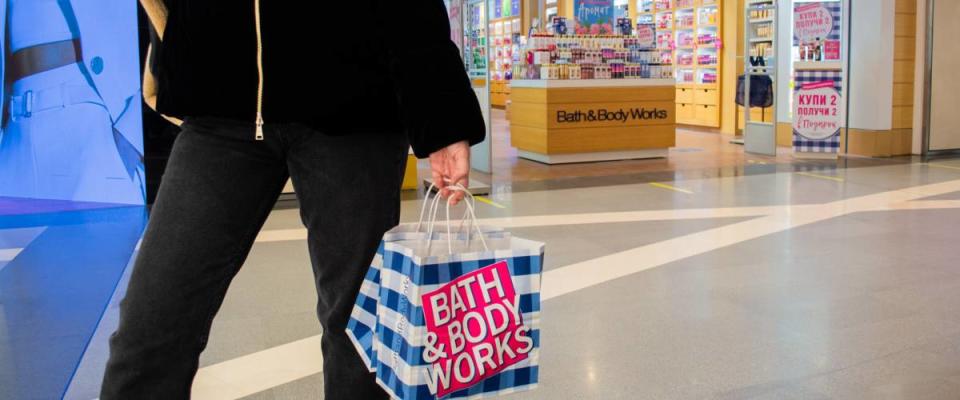 Person with Bath and body works shopping bag walking in front of the store