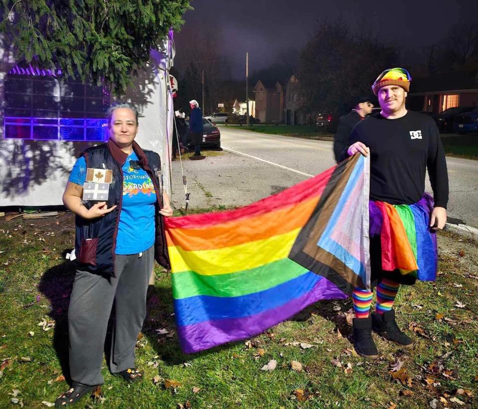 Britt Leroux (left) and her husband John Reh (right) carry a rainbow flag during a Halloween event in October 2023.