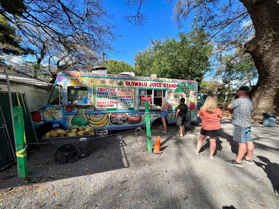 food truck with people lined up outside of it