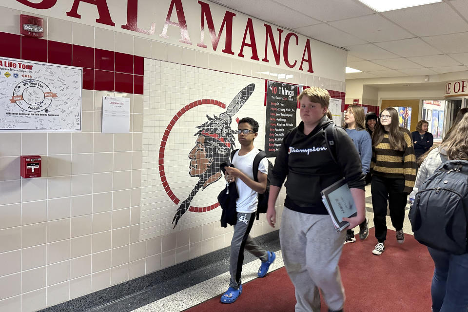 Students walk past a logo that is tiled into the wall at Salamanca High School in Salamanca, N.Y., on April 18, 2023. The school district, located on Seneca Nation of Indians territory, may have to replace its logo after New York passed a ban on the use of Indigenous names, mascots and logos by public schools. (AP Photo/Carolyn Thompson)