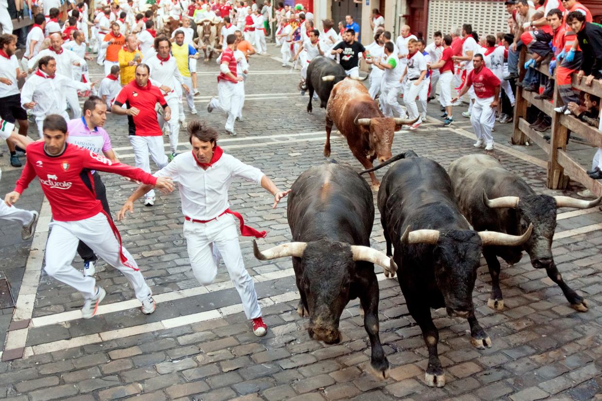 people run from bulls on street during San Fermin festival in Pamplona