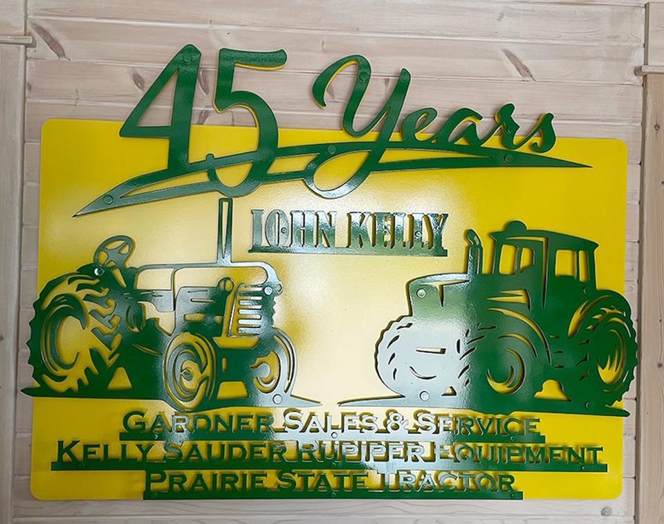 A sign was specially made for John Kelly as a gift for his retirement after 45 years in the implement business.