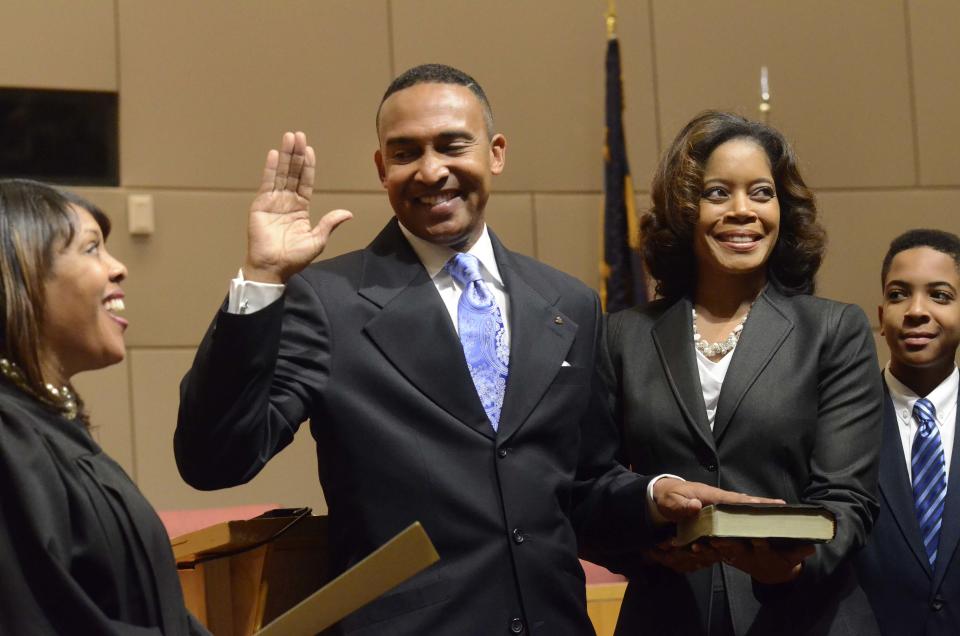 In this Monday, Dec. 2, 2013 photo, Mecklenburg County District Court Judge Tyyawdi Hands, left, administers the oath of office to Patrick Cannon as Charlotte's new mayor, with his wife, Trenna, and son Patrick, next to him, at the Charlotte Government Center, in Charlotte, N.C. U.S. Attorney Anne Tompkins said Wednesday, March 26, 2014, that Charlotte Mayor Patrick Cannon is facing theft and bribery charges. Tompkins says Cannon solicited and accepted bribes from undercover FBI agents posing as real estate developers who wanted to do business in Charlotte. (AP Photo/The Charlotte Observer, Robert Lahser)