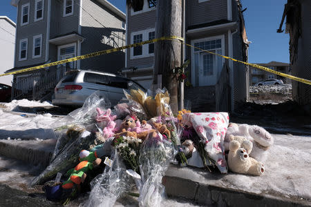 People placed flowers and stuffed animals at an impromptu memorial in front of the house where seven children died from a fatal structure fire in the community of Spryfield in Halifax, Nova Scotia, Canada, on February 20, 2019. REUTERS/Ted Pritchard