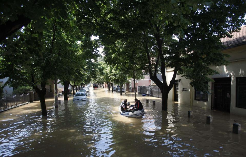 Residents sit on a boat in the flooded town of Obrenovac