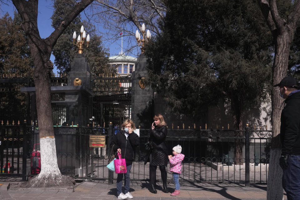 Foreigners stand outside an entrance to the Russian Embassy in Beijing on Tuesday, March 1, 2022. As the West condemns Russia, President Vladimir Putin has vocal supporters in China, where the ruling Communist Party tells its people they are a fellow target of U.S.-led harassment. Public sentiment largely reflects the stance of a ruling party that is the closest thing Putin has to a major ally: The war should stop but the United States is to blame. (AP Photo/Ng Han Guan)