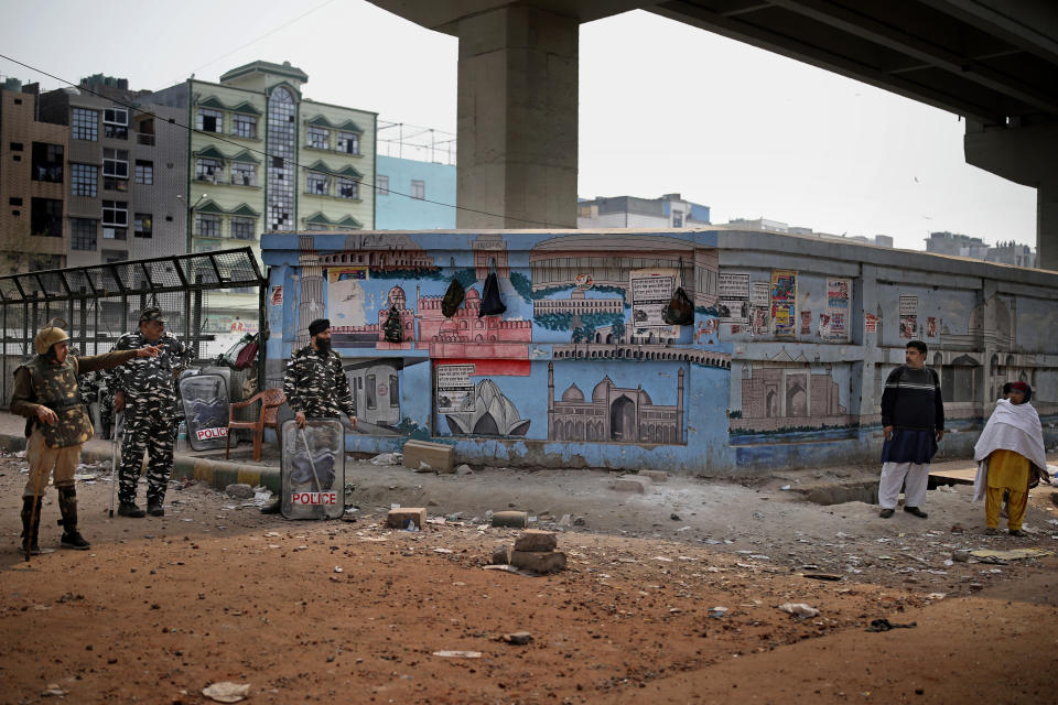 Indian security officers deny passage to an Indian couple as they guard an area after Tuesday's violence in New Delhi, India, Wednesday, Feb. 26, 2020. At least 20 people were killed in three days of clashes in New Delhi, with the death toll expected to rise as hospitals were overflowed with dozens of injured people, authorities said Wednesday. The clashes between Hindu mobs and Muslims protesting a contentious new citizenship law that fast-tracks naturalization for foreign-born religious minorities of all major faiths in South Asia except Islam escalated Tuesday. (AP Photo/Altaf Qadri)