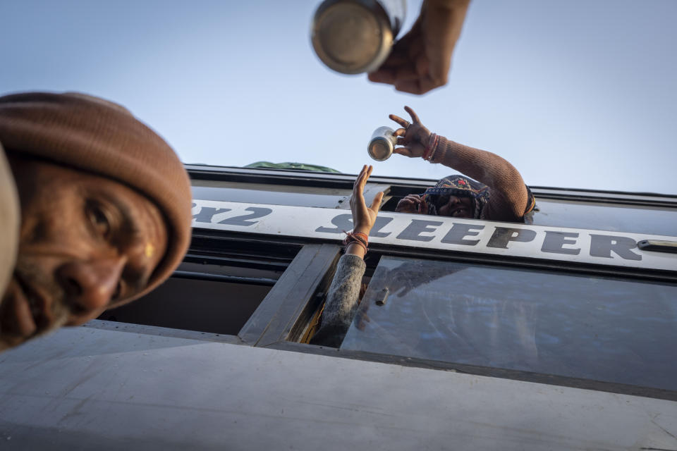 Indian pilgrims deliver tea to their family members through the window of a bus before they embark on a visit to the sacred Pashupatinath temple in Kathmandu, Nepal, Jan. 9, 2024. The centuries-old temple is one of the most important pilgrimage sites in Asia for Hindus. Nepal and India are the world’s two Hindu-majority nations and share a strong religious affinity. Every year, millions of Nepalese and Indians visit Hindu shrines in both countries to pray for success and the well-being of their loved ones. (AP Photo/Niranjan Shrestha)