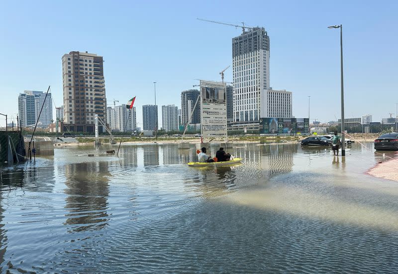 A volunteer uses a kayak during a rescue operation through a road flooded due to heavy rains in Dubai