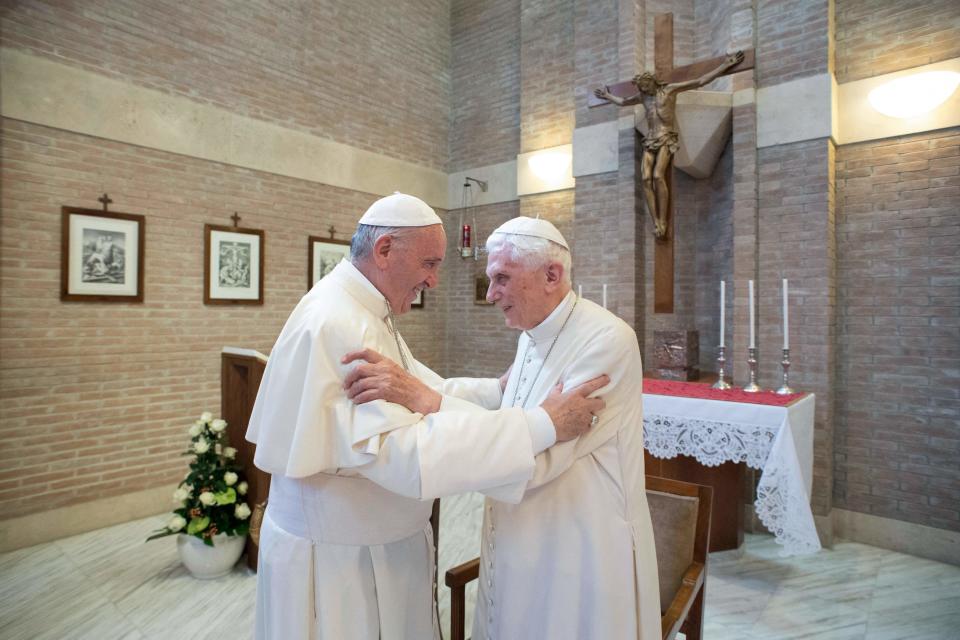 This picture released on Feb. 15, 2018, by the Vatican press office shows Pope Francis, left, greeting Pope Benedict XVI at the Vatican on June 28, 2017.