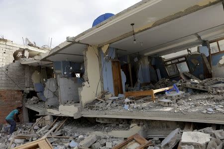 A resident looks at a collapsed building in the town of Canoa, after an earthquake struck off the Pacific coast, in Ecuador April 18, 2016. REUTERS/Henry Romero