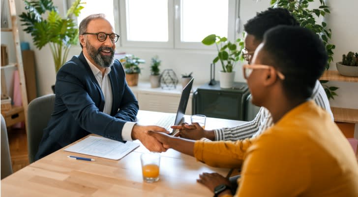 A financial advisor shakes hands with clients he helps manage an inherited IRA. 