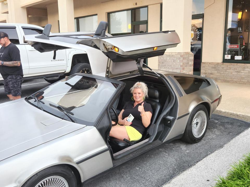 Fountain City Social owner Lindsey Chapman checks out a customer’s DeLorean. The car’s owner heard about the '80s-themed bar and drove from Sevierville to check it out.