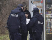 Polish police taking down the name and address of a young man to fine her for not wearing a mask in public space as Poland's authorities stepped up anti-COVID-19 measures after the nation registered three consecutive record numbers of new infections this week, in Warsaw, Poland, Friday, March 26, 2021.(AP Photo/Czarek Sokolowski)