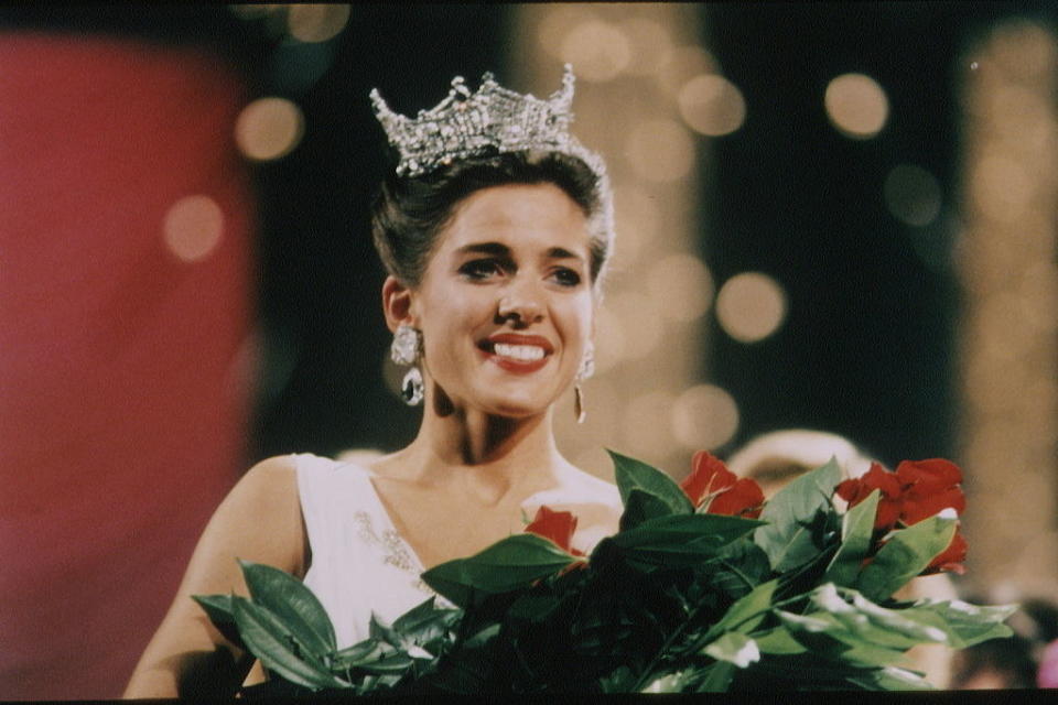 Whitestone smiling and holding roses after being crowned