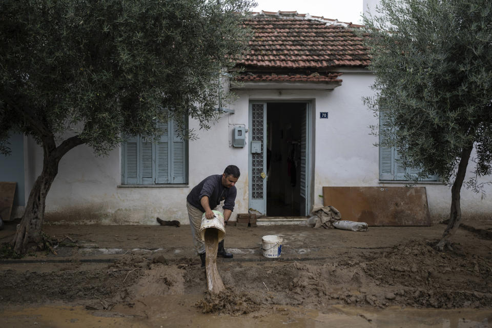 Apostolis Sirtariotis, 47, empties a bucket of water from his flooded home in the storm-hit city of Volos, Greece, where power and water outages remained in some districts, on Friday, Sept. 29, 2023. Bad weather has eased in central Greece leaving widespread flooding and infrastructure damage across the farming region that has been battered by two powerful storms in less than a month. (AP Photo/Petros Giannakouris)