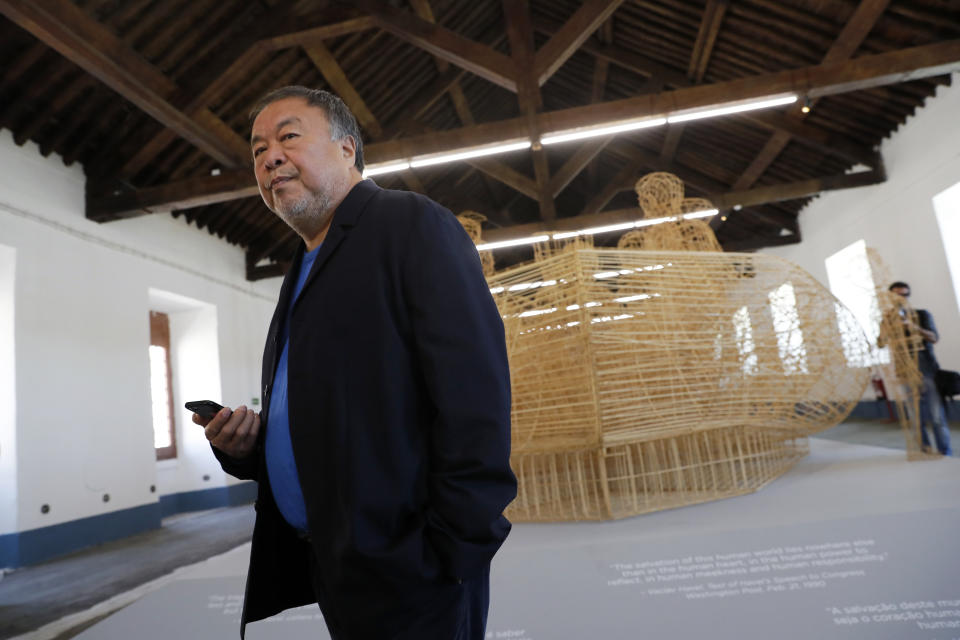 Dissident Chinese artist Ai Weiwei walks by his work "Life Cycle", a migrants' boat made of bamboo, during a press preview of his new exhibition "Rapture" in Lisbon, Thursday, June 3, 2021. The world-renowned artist is putting on the biggest show of his career, and he is doing it in a place he's fallen in love with: Portugal. (AP Photo/Armando Franca)