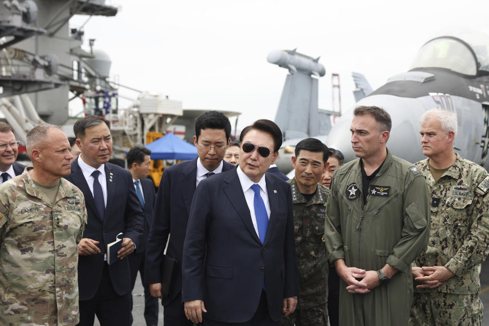 South Korean President Yoon Suk Yeol, center, boards the USS Theodore Roosevelt aircraft carrier at the South Korean naval base in Busan, South Korea, Tuesday, June 25, 2024 (South Korean Presidential Office/Yonhap via AP)