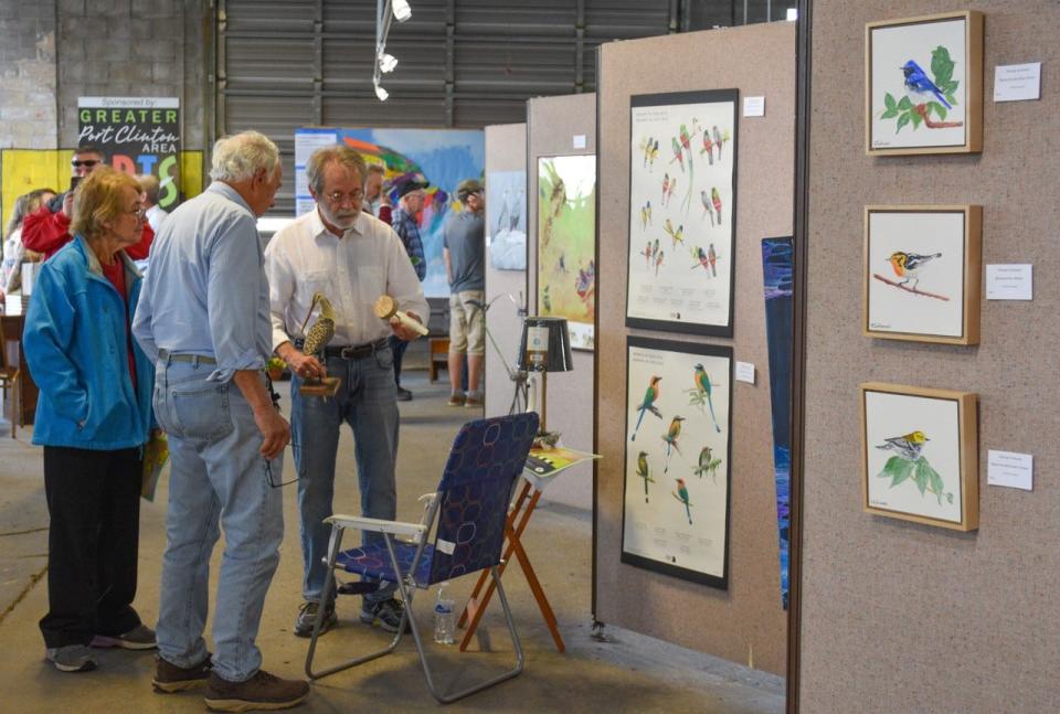 Woodcarver Paul Wilford of Port Clinton talks with visitors about his work during the "Feather to Frame" opening reception.