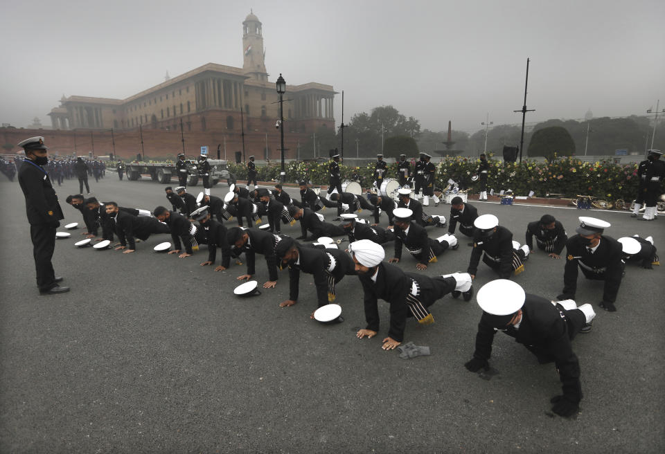 Indian Navy sailors do push-ups to keep themselves warm during rehearsals for the upcoming Republic Day parade at the Raisina hills, the government seat of power, in New Delhi, India, Monday, Jan. 18, 2021. Republic Day marks the anniversary of the adoption of the country's constitution on Jan. 26, 1950. Thousands congregate on Rajpath, a ceremonial boulevard in New Delhi, to watch a flamboyant display of the country’s military power and cultural diversity. (AP Photo/Manish Swarup)