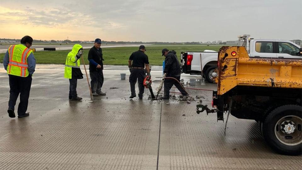 Crews work to repair a damage to a runaway caused by a lightning strike at Hobby Airport in Houston, Texas, on May 13, 2024.
