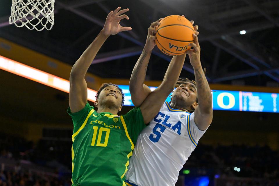 Oregon Ducks forward Kwame Evans Jr. (10) and UCLA Bruins guard Brandon Williams (5) reach for a rebound in the first half at Pauley Pavilion Feb. 3, 2024, in Los Angeles.