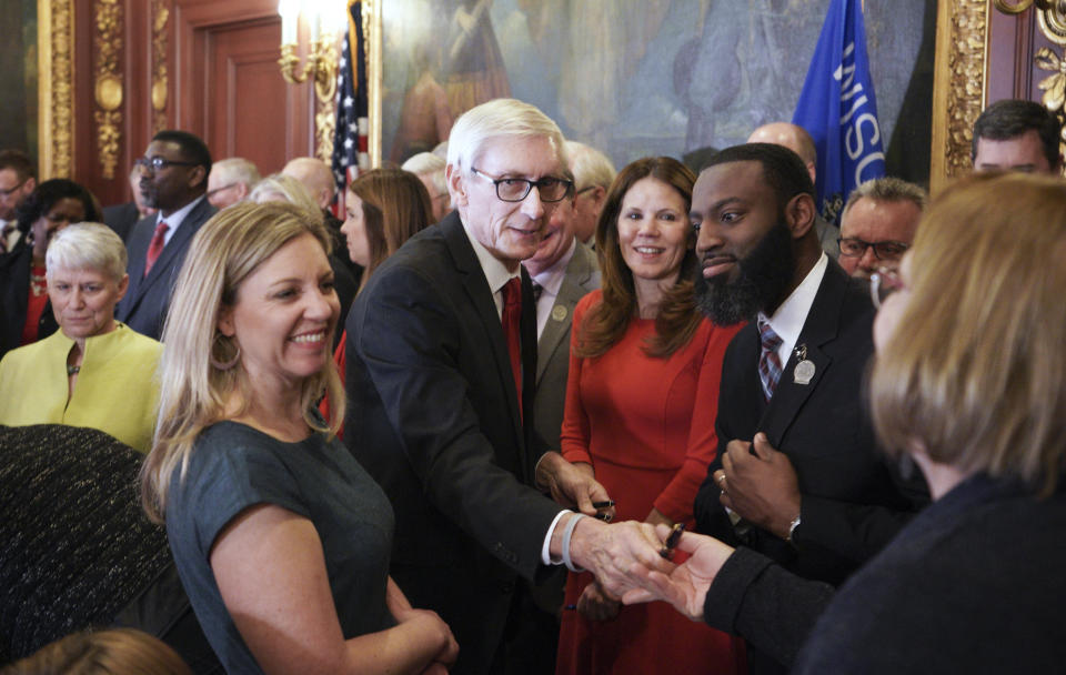 FILE - In this Feb. 6, 2020 file photo, Wisconsin Govenor Tony Evers hands out pens after signing an executive order on in Madison, Wis. Gov. Evers made it official Saturday, June 5, 2021, announcing his bid for a second term in the battleground state where he stands as a Democratic block to the Republican-controlled state Legislature. (Steve Apps/Wisconsin State Journal via AP File)