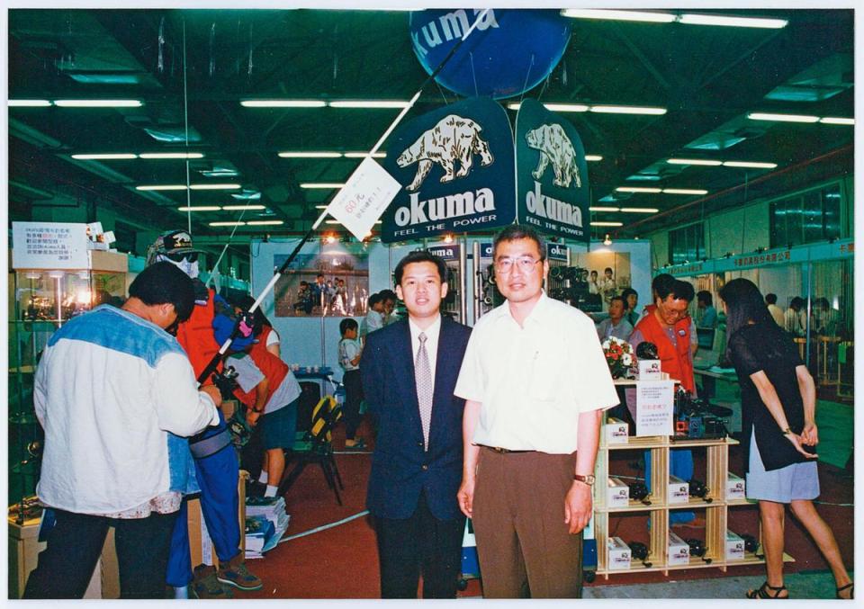 張良任（右）不放棄每一次行銷品牌的機會，圖為他早年參加高雄釣具展，親自接待新加坡貿易商。（寶熊漁具提供）